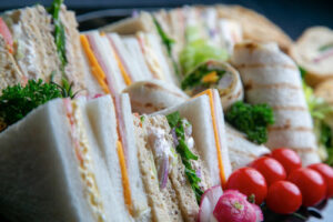 Assortment of sandwiches and wraps on a black tray