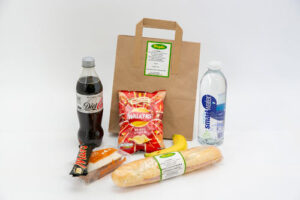 Brown bag lunch with drinks, crisps and a fresh baguette roll